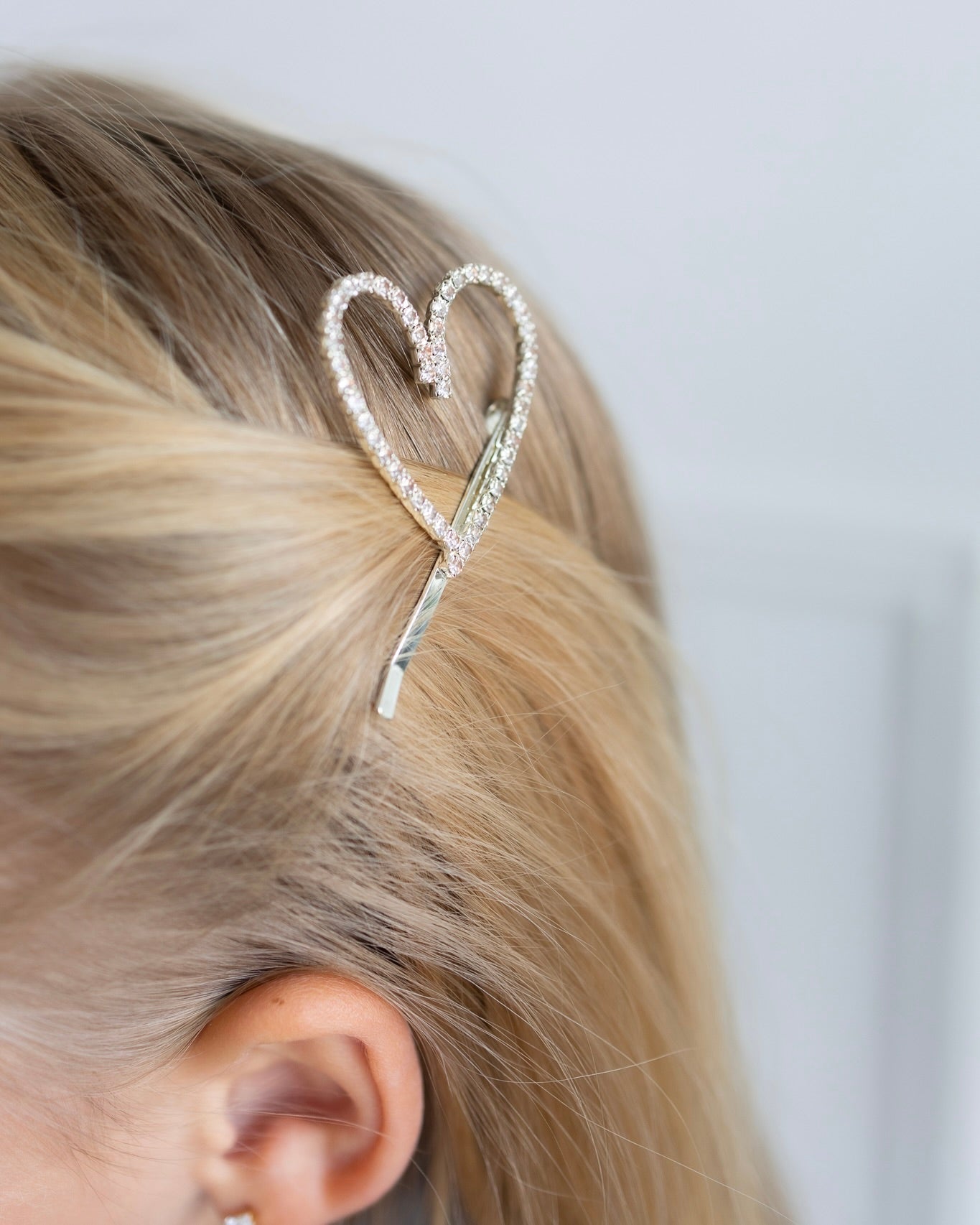 Heart-shaped hair clip worn by a child, sparkling kids hair accessory
