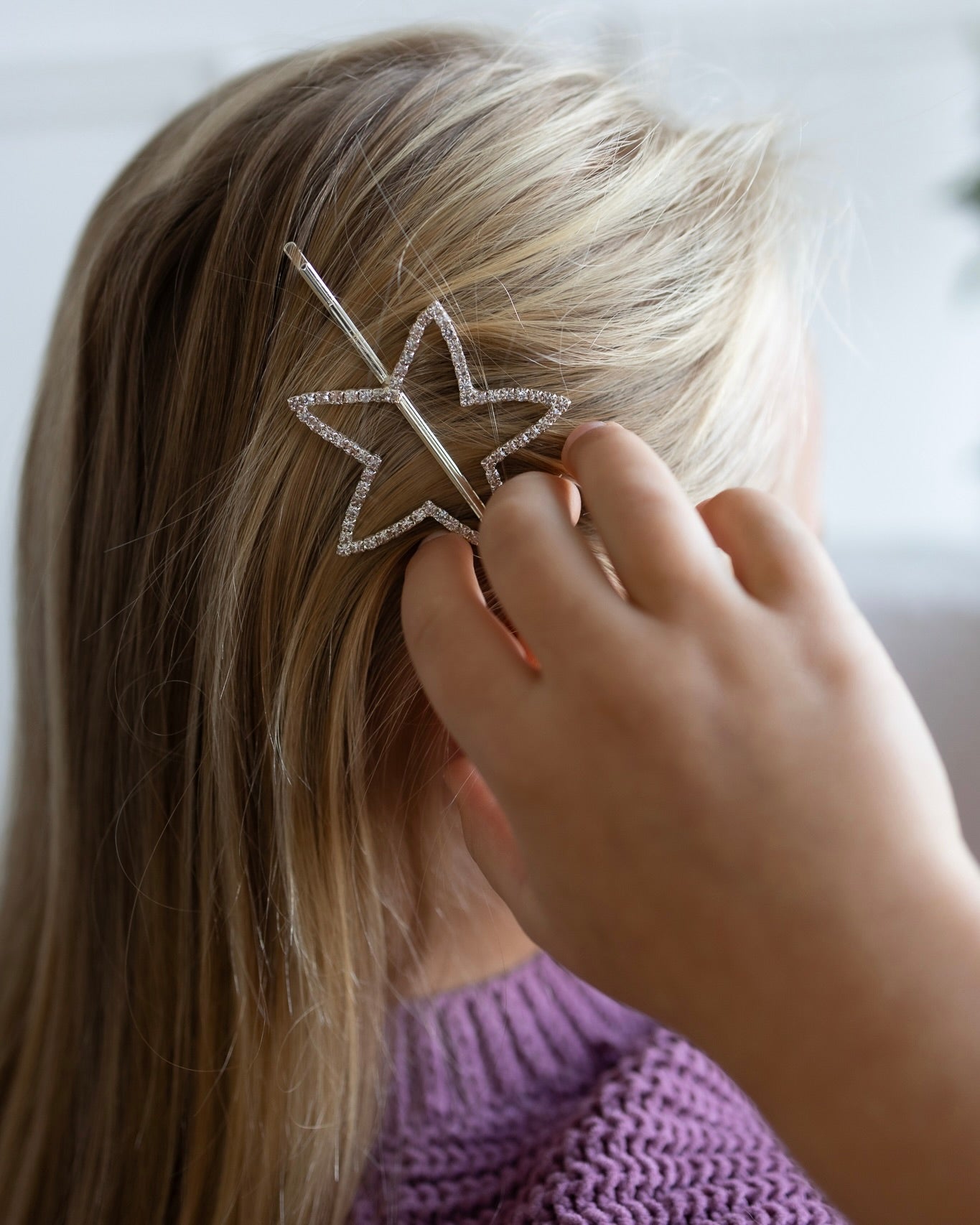 Star-shaped hair clip worn by a child, sparkling kids hair accessory