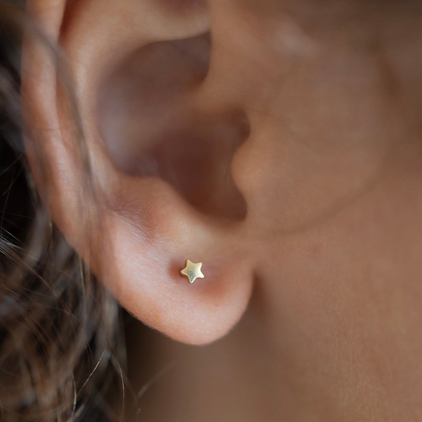 Child wearing a star-shaped titanium stud earring