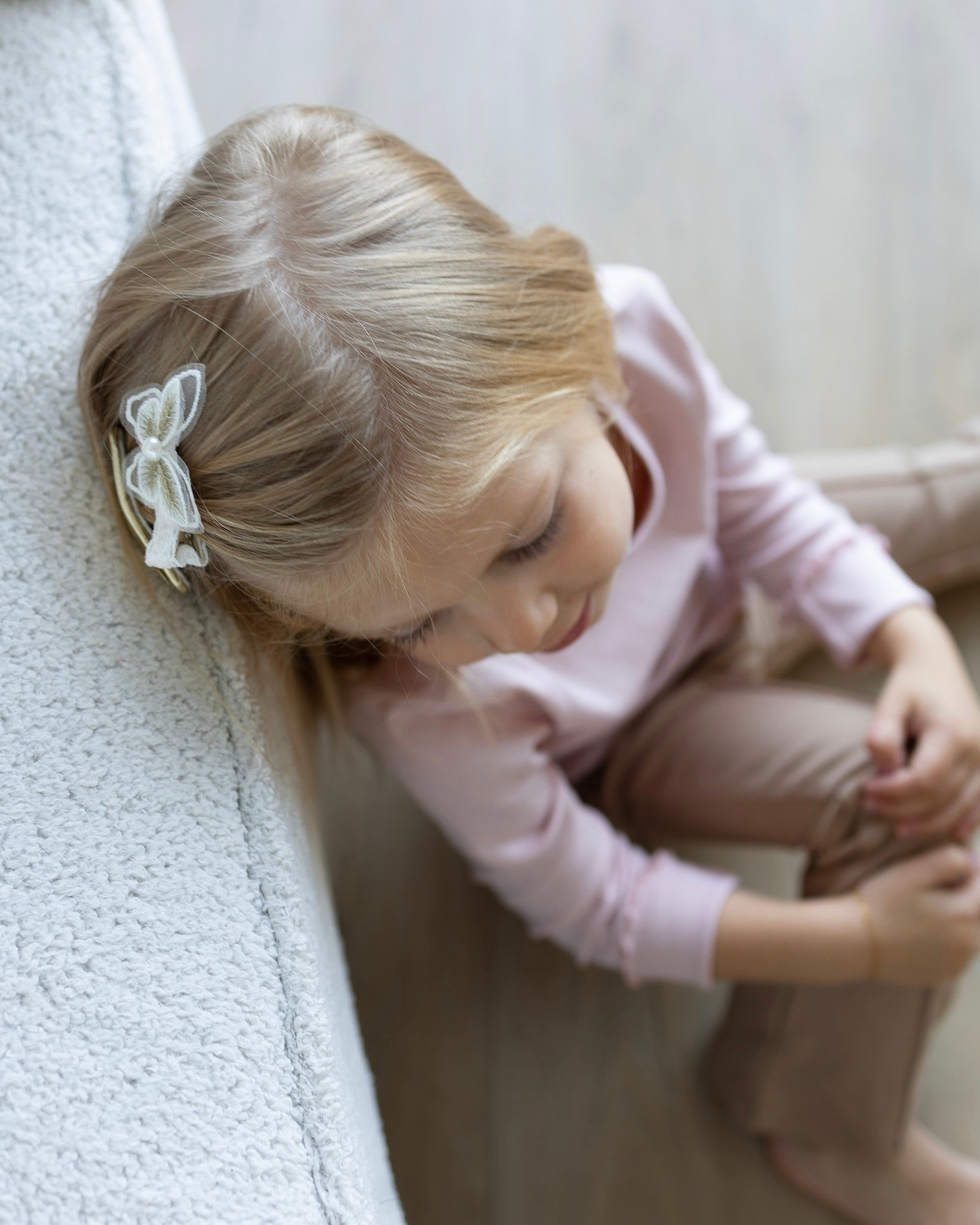 Child wearing a delicate white hair bow clip, soft everyday hair accessory for children
