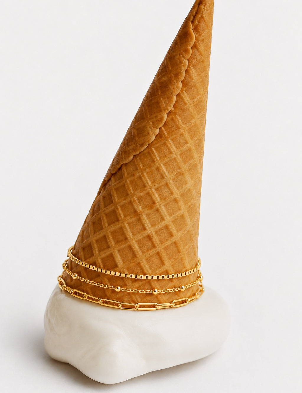 Three stacked gold bracelets for kids displayed in a creative ice cream inspired setup.